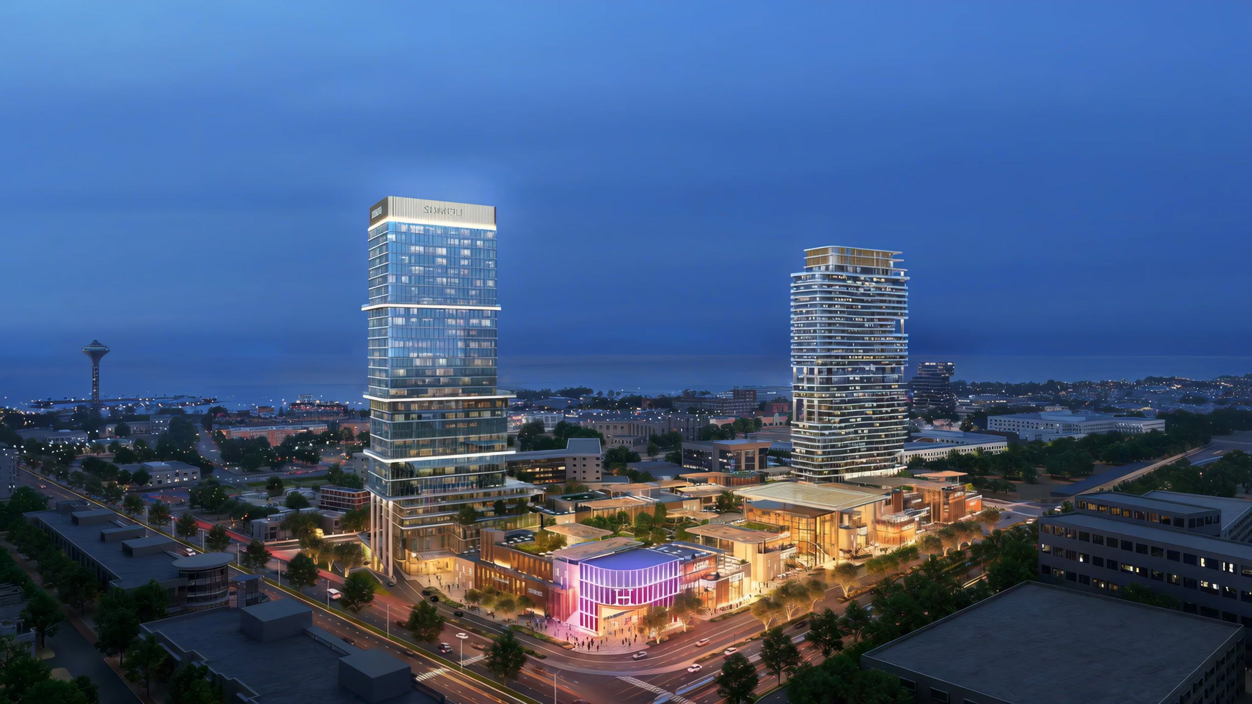 Sumou Center at dusk, two towers above a glowing podium with the Gulf behind